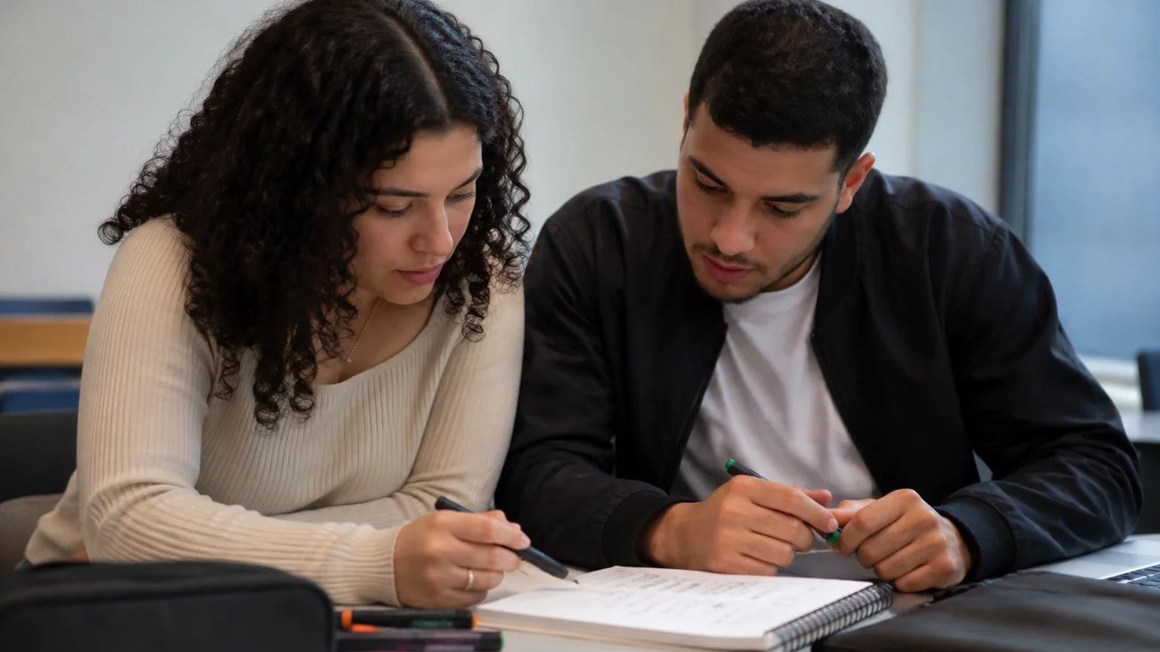 Estudantes de mochila nas costas conversando no corredor de uma universidade